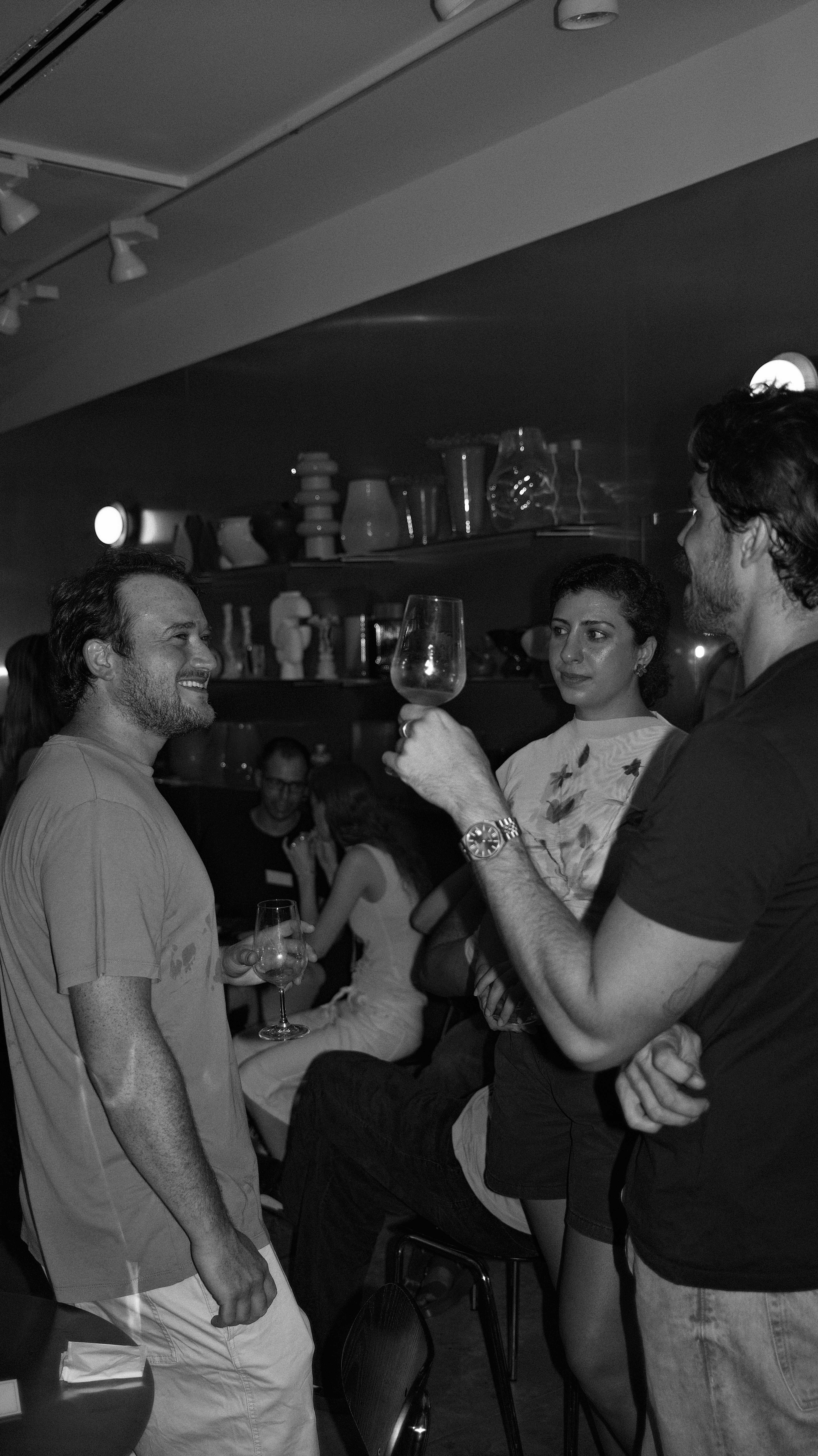 Guests in conversation at the bar, in black and white