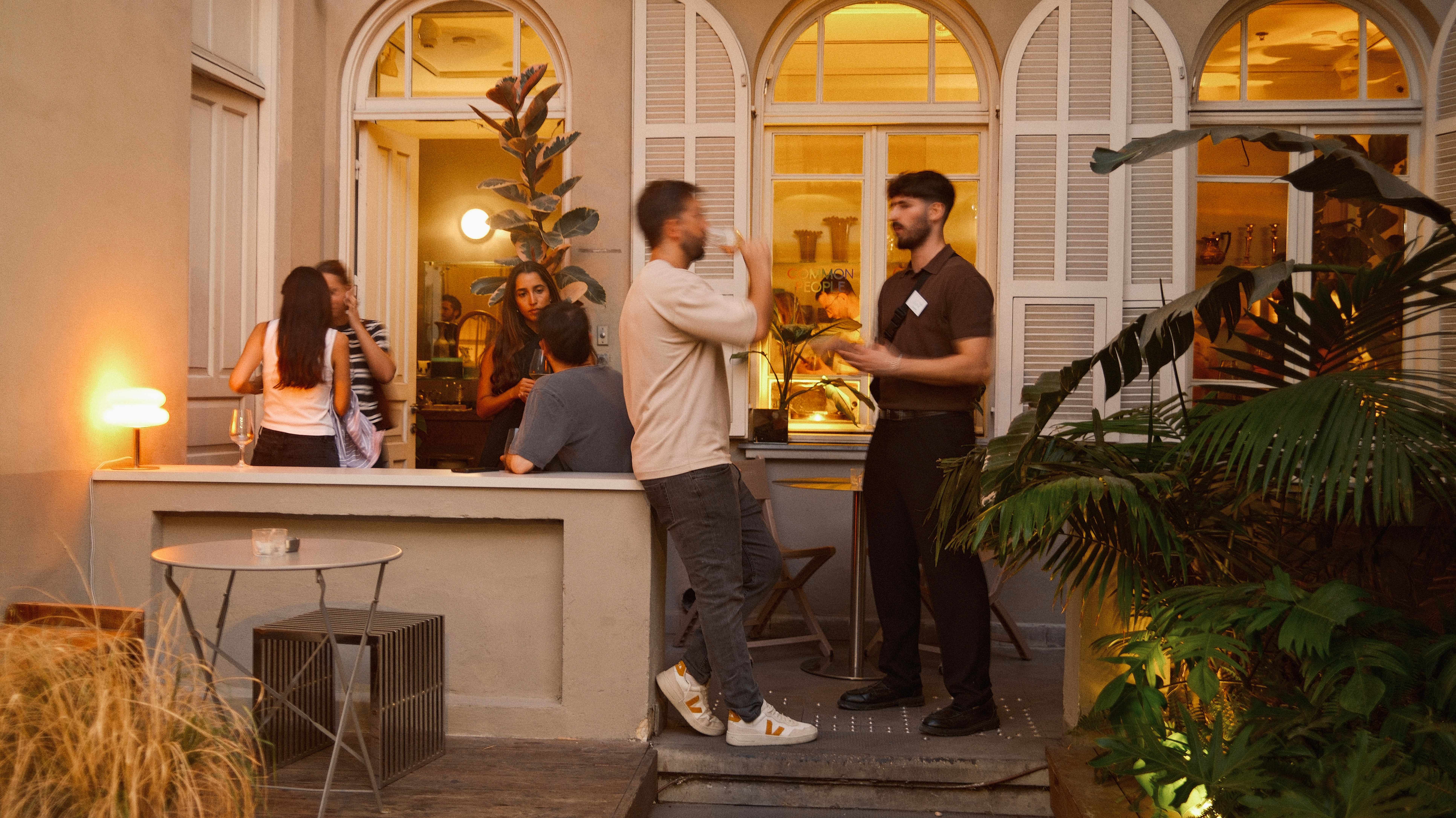 Golden-hour conversation on the terrace at a 6PM Club gathering