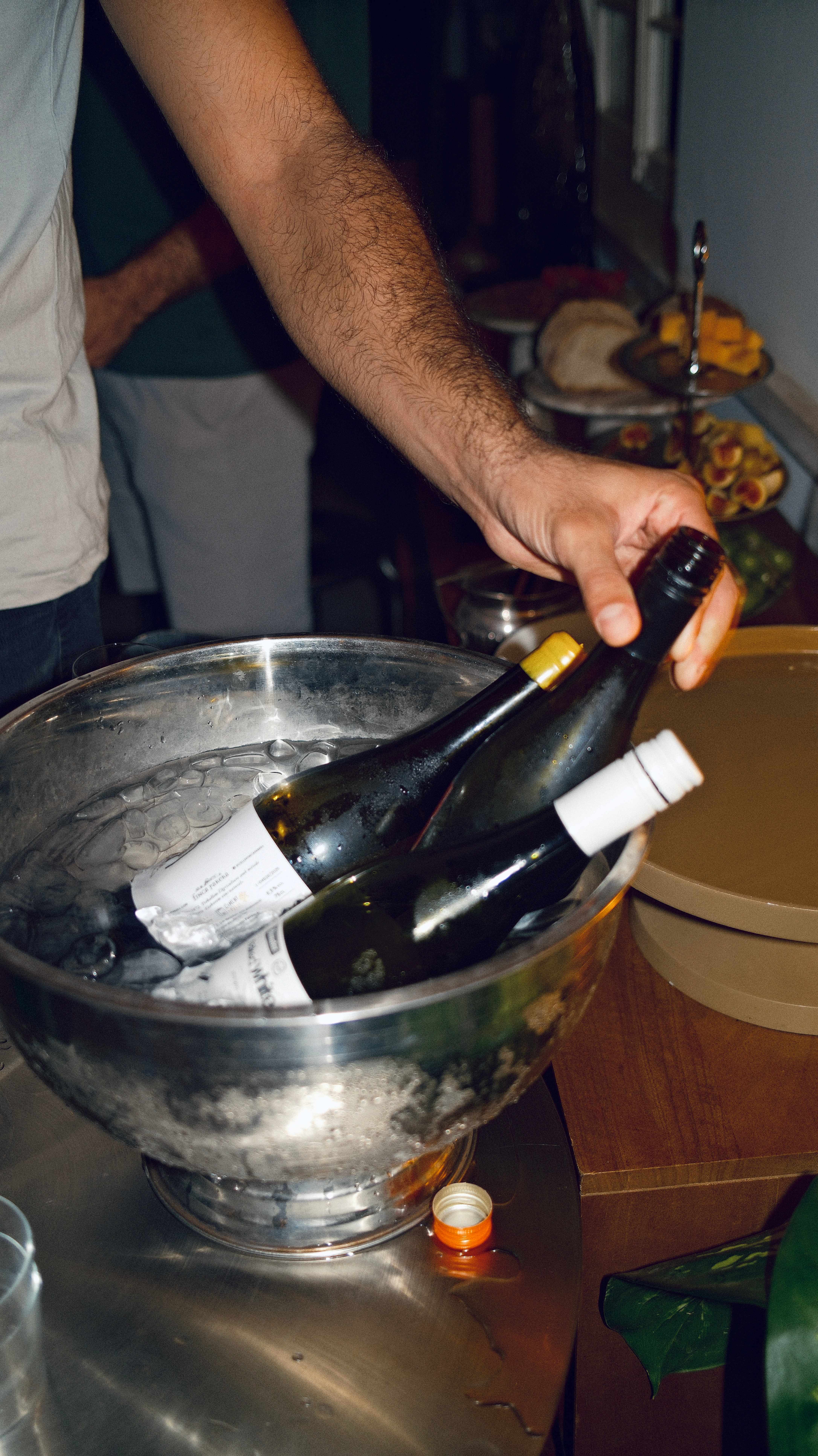 A bottle of wine pulled from an ice bucket by candlelight