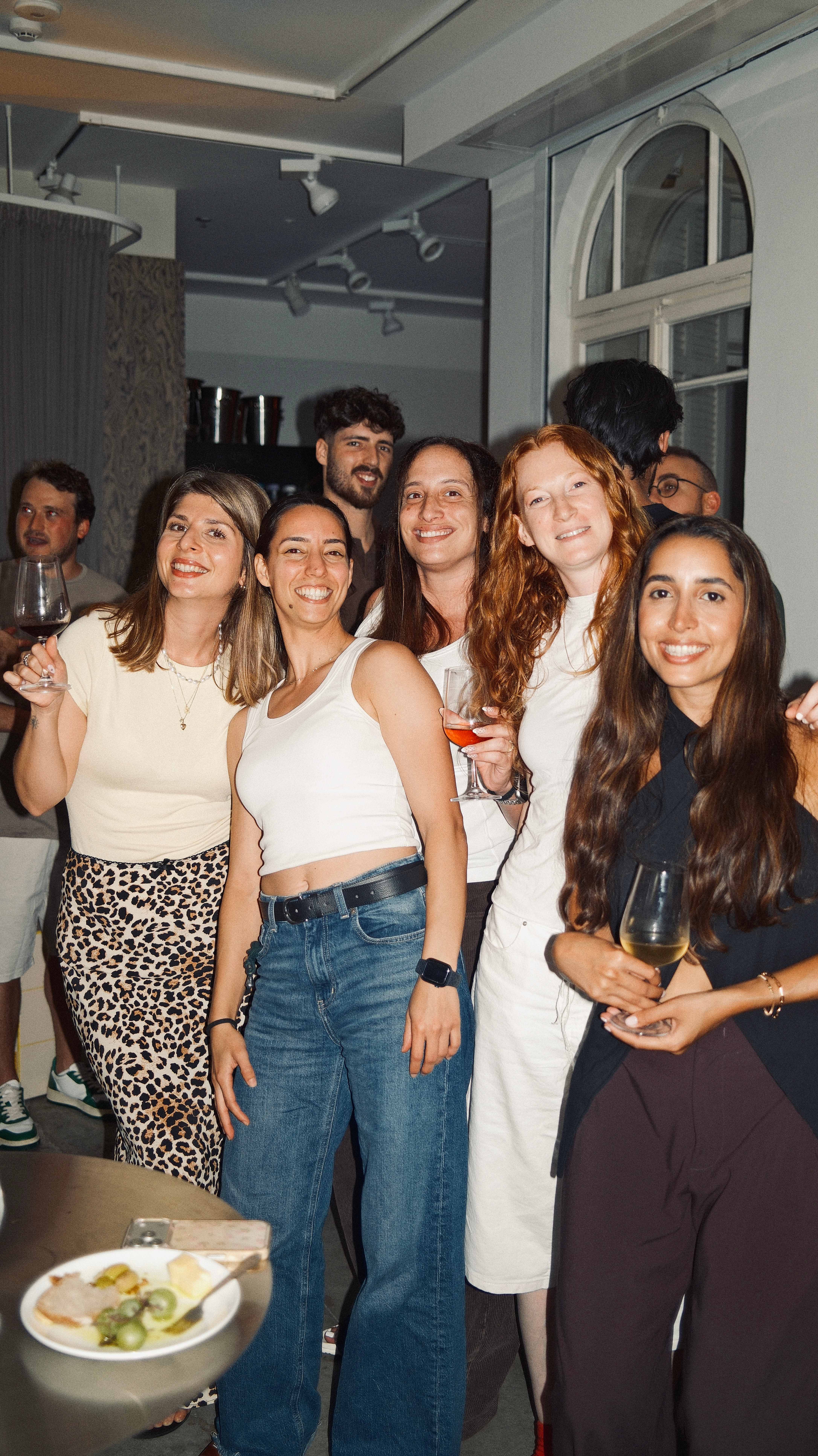 Smiling guests raising their glasses at a 6PM Club evening